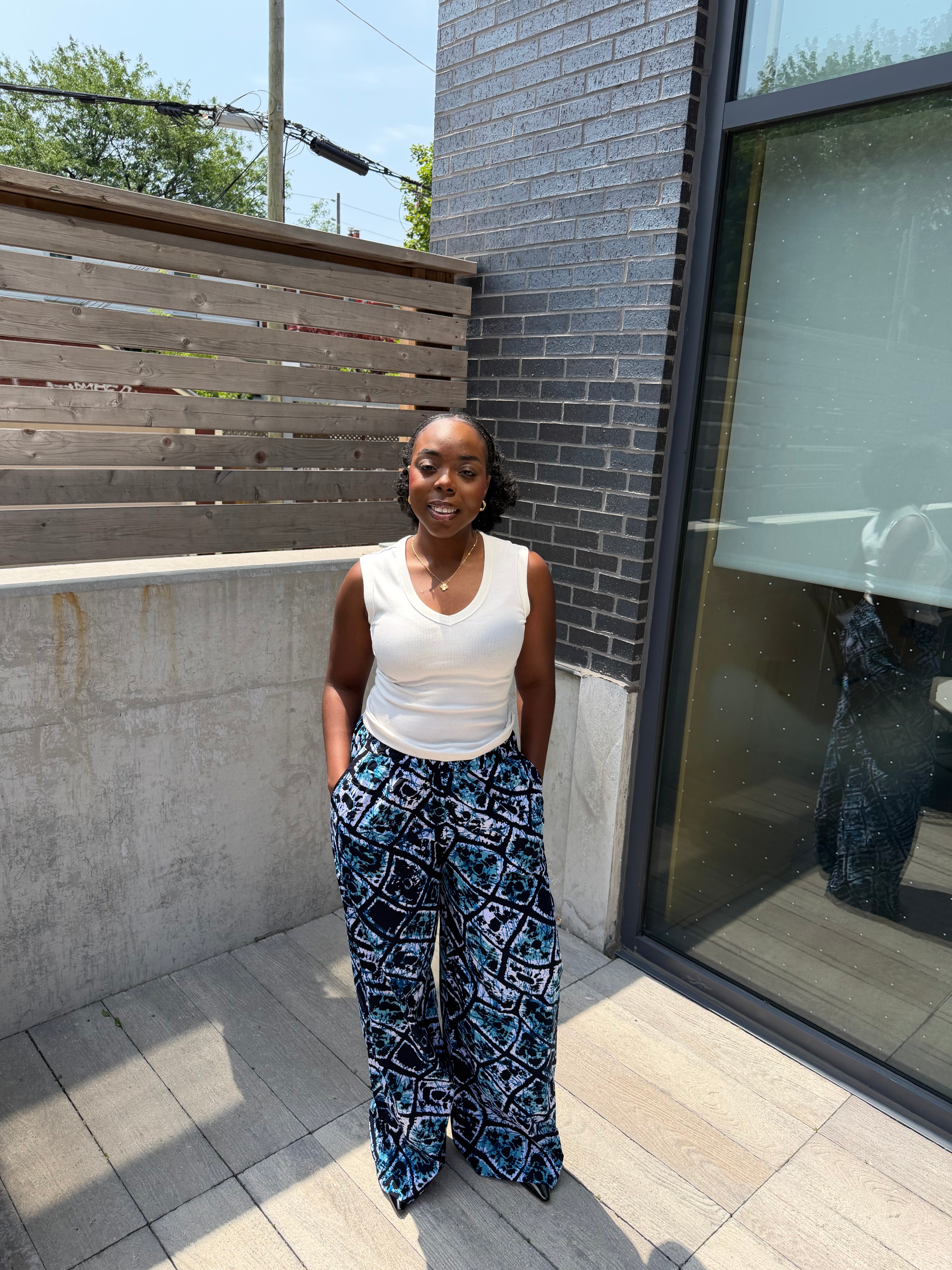Dark patterned Chi wide-leg pants, modelled outdoors.